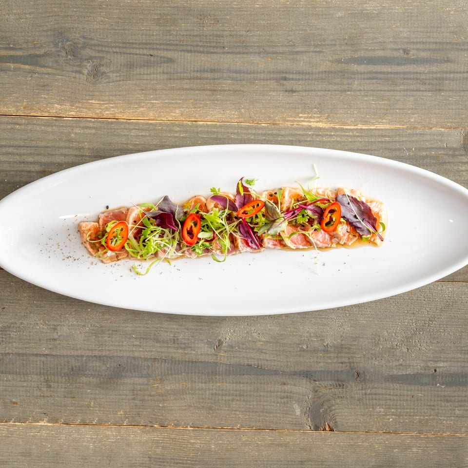 Yellowtail sashimi with chili and microgreens
