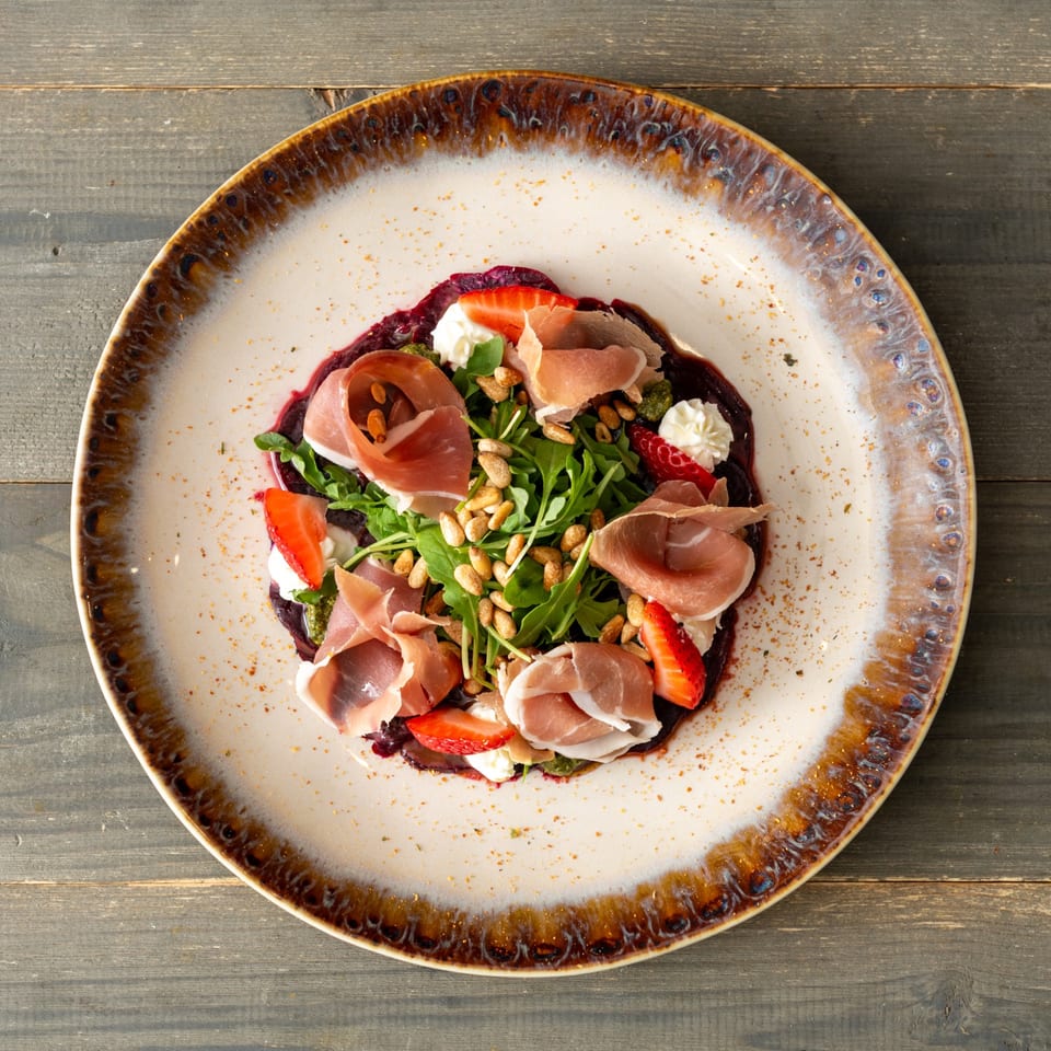 Colorful salad with prosciutto and strawberries